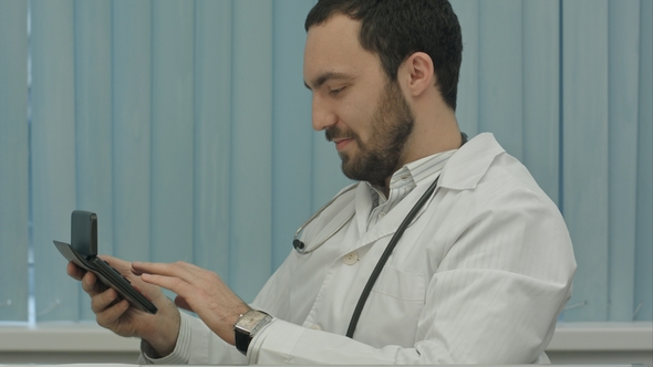 Bearded Doctor with a Calculator. Make Calculations of Price and Satisfied of It