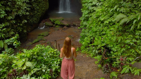 Aerial Shot of a Young Woman Visiting the Leke Leke Waterfall in Jungles of Bali, Indonesia