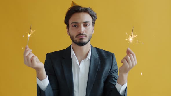 Slow Motion Portrait of Upset Mixed Race Person Waving Sparklers and Looking at Camera with Boredom