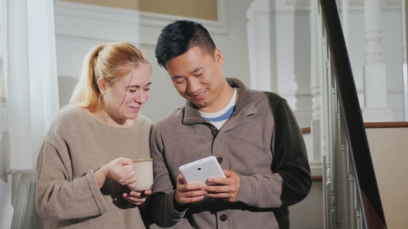 A Young Couple of Chiathletes Utrophy of News on a Film. Woman Holding a Cup of Tea