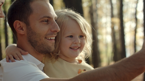 Father with  Daughter Taking Selfie with Phone in Autumn Park