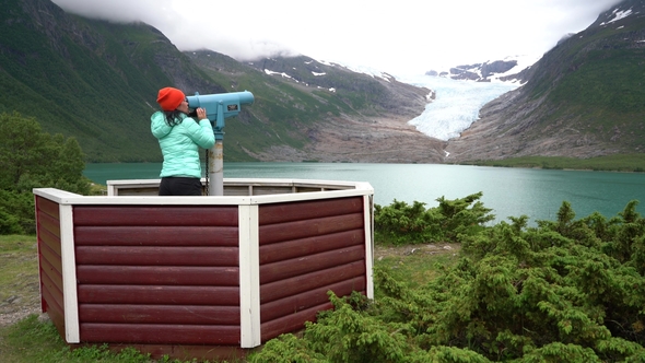 Svartisen Glacier in Norway. Tourist Girl Looking Glacier.