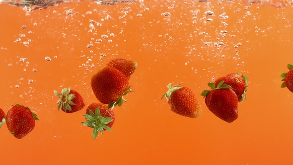 Fresh Strawberry Fall Into Water on Orange Background. Summer Berries in Clean Liquid