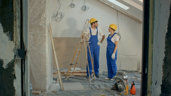 Two Housebuilders Discussing at Construction Site