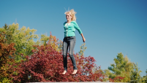 A Middle Aged Woman High Up on a Trampoline