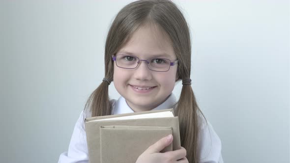 Portrait of Little Cute Smiling School Girl in Glasses with Books