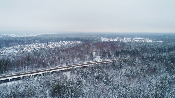 Train Transports Loaded Carriages Against Winter Landscape