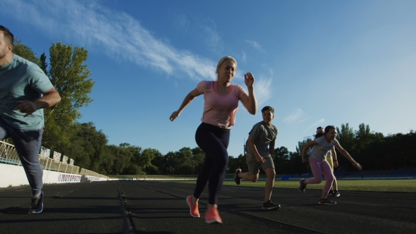 Family Running Sprint for Time on Stadium