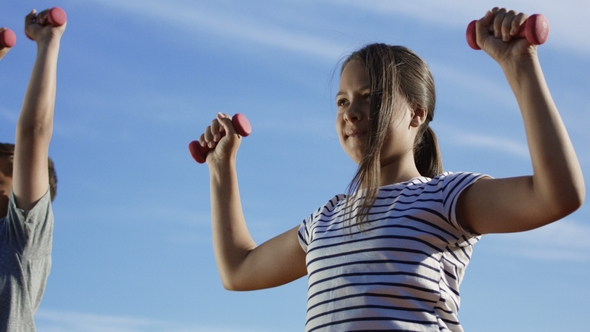 Children Training with Dumbbells Outside