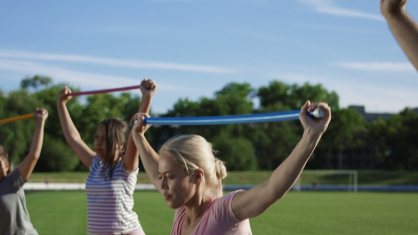 Woman with Kids Exercising on Sports Ground