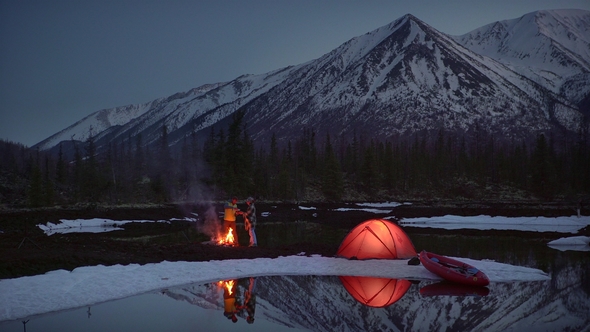 a Couple Drinking and Warming in a Camping By the Fire in Mountains