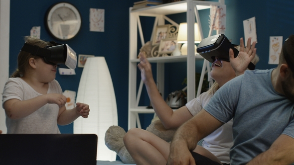 Family Playing VR Game Together on Bed