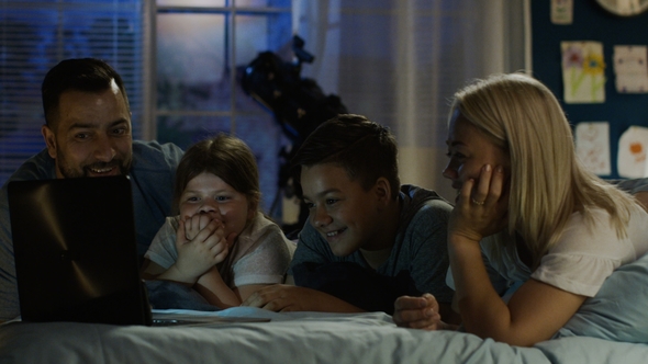 Content Family Watching Funny Movie on Laptop