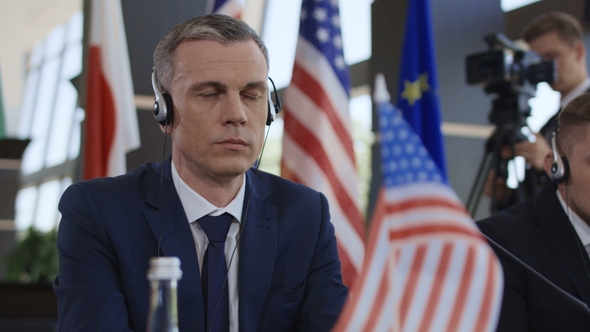 Concentrated Politician Listening To Translation on Conference