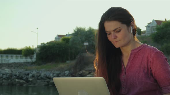 A Young Woman Works With Laptop By The Sea