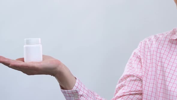 Serious Elderly Woman Holding Pills Jar and Looking at Camera, Fake Pharmacy