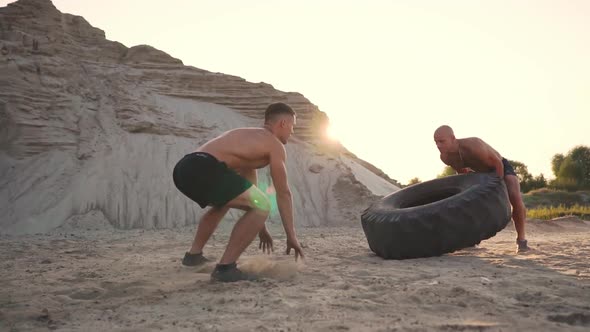 Two Muscular Open-chested Athletes Train in Active Mode on the Beach Doing push-UPS