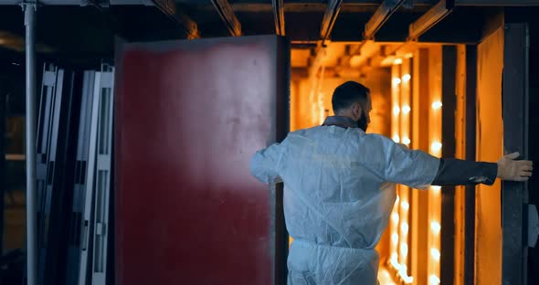 Worker Baking Metal Products with Powder Paint