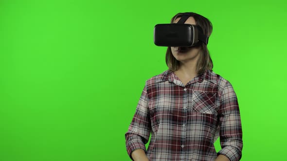 Young Woman Using VR Headset Helmet To Play Game, Showing Side Advertising Area. Chroma Key