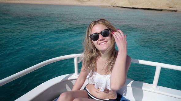 Portrait of a Young Beautiful Sexy Caucasian Woman on a Yacht in Bikini and Sunglasses