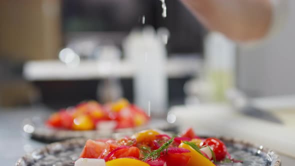 Hand of Chef Dressing Salad with Lemon Juice