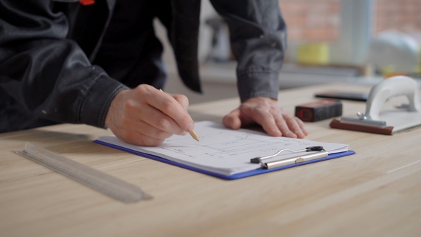 Shof of a Builder Working with Papers Indoor.