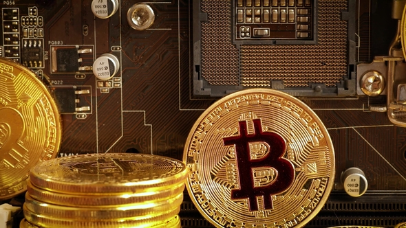 Gold Bit Coin BTC Coins on the Motherboard. Bitcoin Is a Worldwide Cryptocurrency