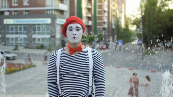 Funny Mime in Red Beret Show Thumb Up at Fountain Background