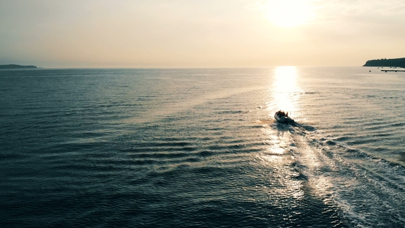 Speedboat Is Floating Across Open Water at a Sunset