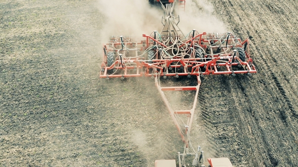 Sowing Truck Is Scattering a Meadow with Seeds While Moving Along It