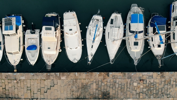 Docks with a Line of Yachts Moored To It in a Top View