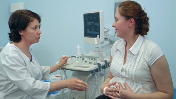 Female Doctor Explaining Medical Procedure To Future Mother