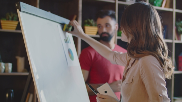 Businesswoman Cleaning Whiteboard in Office. Woman Preparing Planning Board