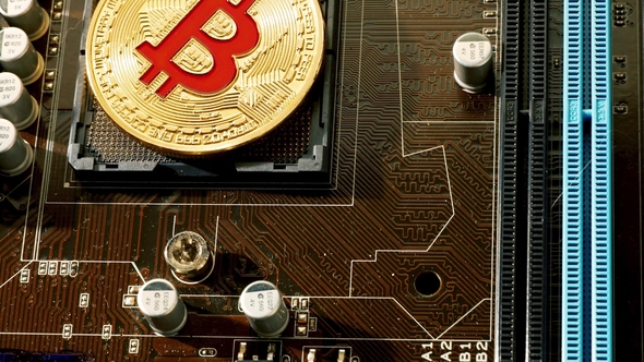 Gold Bit Coin BTC Coins on the Motherboard. Bitcoin Is a Worldwide Cryptocurrency