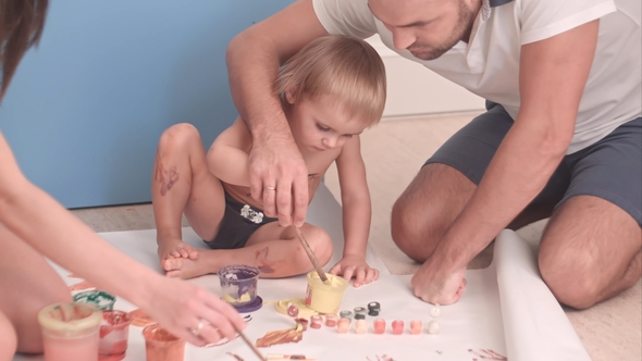 Young Father Teaching His Kid Boy How To Paint