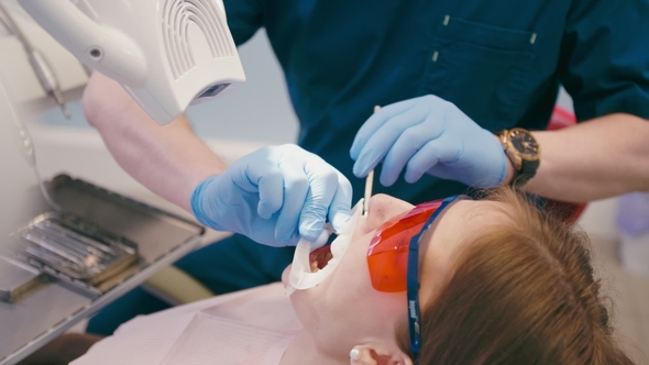 Dentist Is Preparing Patient To Tooth Whitening Procedure in the Dental Office