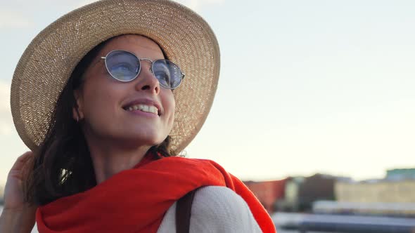 Portrait of a happy young girl in a hat in a summer city