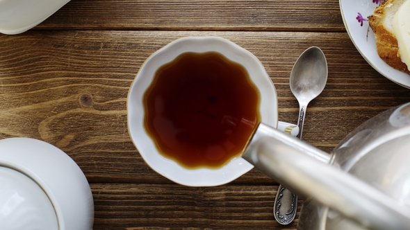 Tea From the Kettle Slowly Pour Into Porcelain Cup