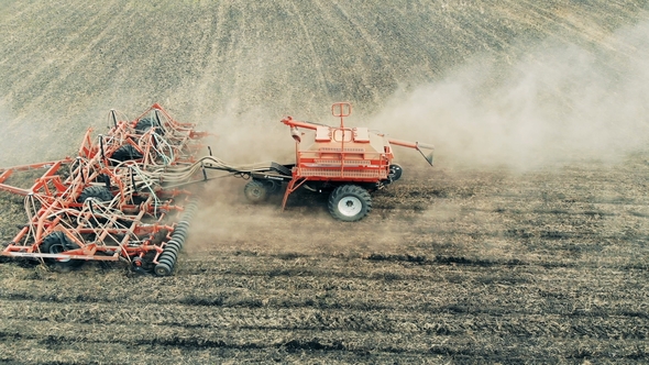 Agricultural Tractor Across a Massive Field. Sowing Agricultural Crops at Field