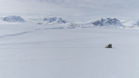 People Riding on Vintage Snowmobile. Antarctica.