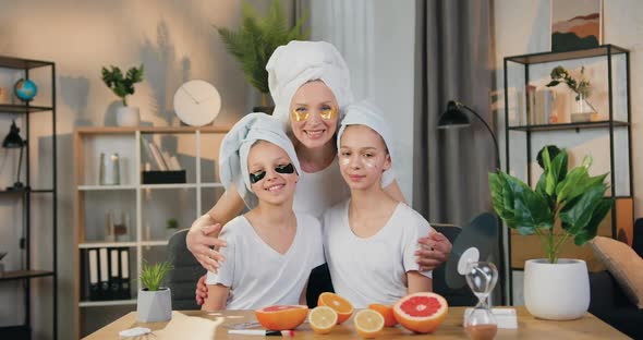 Mother Hugging Her Two Teen Daughters while they All Applying Hydrogel Refreshing Eye Patches