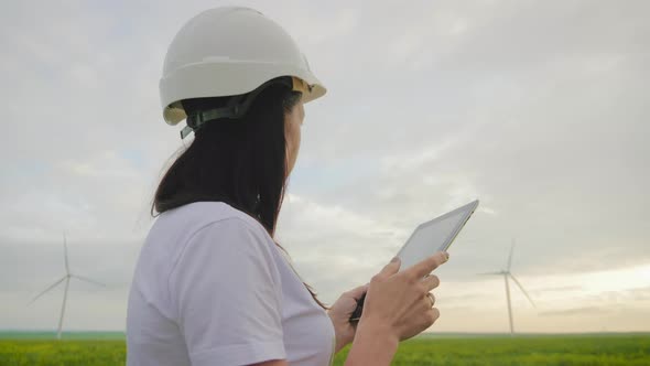 Woman Engineer Working in Wind Turbine Electricity Industrial at Sunset