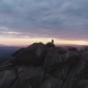 Aerial View of the Lonely Man Standing on Top of a Cliff and Enjoying the Sunset. - VideoHive Item for Sale
