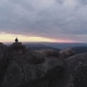 Aerial View of the Lonely Man Standing on Top of a Cliff and Enjoying the Sunset. - VideoHive Item for Sale
