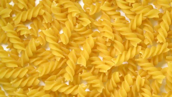 Uncooked fusilli pasta rotating top view