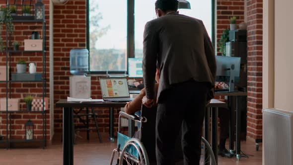 African American Man Helping Woman in Wheelchair with Transportation