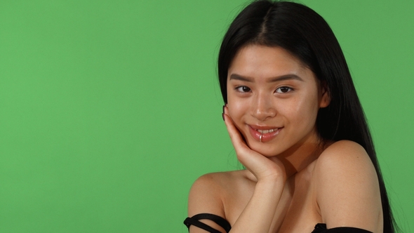 Attractive Asian Young Woman Posing Dreamily on Green Chromakey