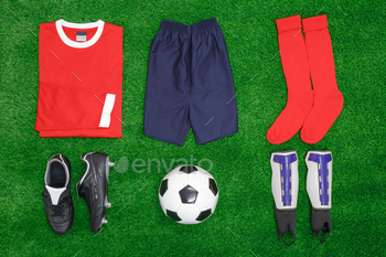 n grass, with shirt, shorts,socks, boots, shin pads and ball.