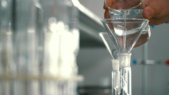 Chemist Pouring Alcohol Into a Flask Through Funnel alt