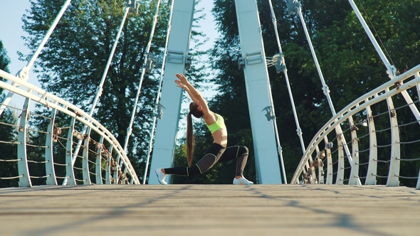 Active Woman Exercising and Stretching in City Park on Footbridge.